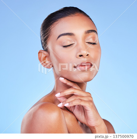 Beauty, cosmetics and skincare with face of woman in studio for health, dermatology and facial. Glow, self care and wellness with person on blue background for spa treatment, grooming and makeup Beauty, cosmetics and skincare with face of woman in studio for health, dermatology and facial. Glow, self care and wellness with person on blue background for spa treatment, grooming and makeup 137500970