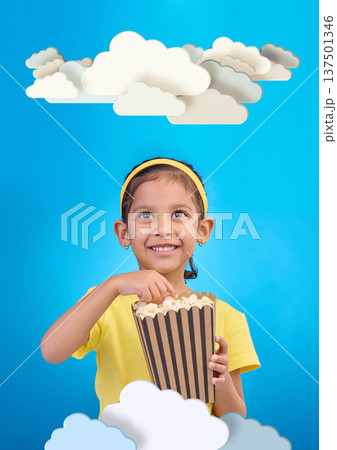 Paper, cloud and girl child with popcorn in studio for cinema, fantasy or creative space on blue background. Kindergarten, lesson and kid with snack for movie, learning or creativity and television Paper, cloud and girl child with popcorn in studio for cinema, fantasy or creative space on blue background. Kindergarten, lesson and kid with snack for movie, learning or creativity and television 137501346