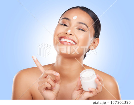 Portrait, happy woman and jar of face cream in studio, advertising lotion and glowing skincare on blue background. Model, facial beauty and container of moisturizer, sunscreen or cosmetic dermatology Portrait, happy woman and jar of face cream in studio, advertising lotion and glowing skincare on blue background. Model, facial beauty and container of moisturizer, sunscreen or cosmetic dermatology 137501350