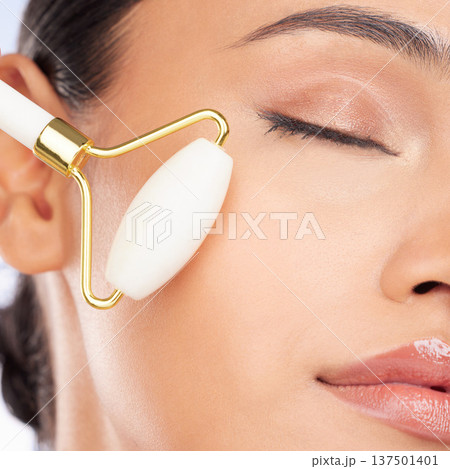 Woman, face roller and closeup for beauty, healthy skincare benefits and aesthetic dermatology. Model, crystal cosmetics product and facial massage tools for lymphatic drainage, collagen and shine 137501401