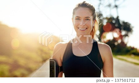 Fitness, portrait and happy woman with earphones outdoor on road at sunrise, training workout or exercise. Listening to music, smile and face of athlete in nature for wellness, healthy body or sport Fitness, portrait and happy woman with earphones outdoor on road at sunrise, training workout or exercise. Listening to music, smile and face of athlete in nature for wellness, healthy body or sport 137501712