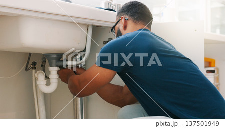 Plumber black man, kitchen and sink maintenance with tools, focus and pipe repair for drainage in home. Entrepreneur handyman, plumbing expert or small business owner in house for fixing water system Plumber black man, kitchen and sink maintenance with tools, focus and pipe repair for drainage in home. Entrepreneur handyman, plumbing expert or small business owner in house for fixing water system 137501949