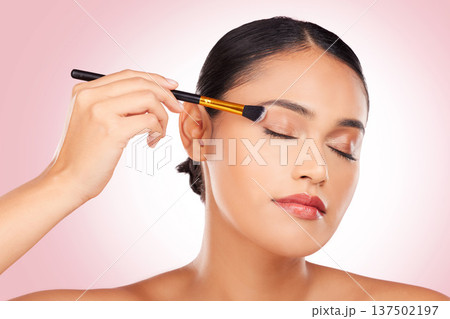 Woman, makeup and eye brush in studio for beauty, skincare or face application on pink background. Young model, dermatology and cosmetics tools for eyeshadow glow, facial powder or aesthetic makeover Woman, makeup and eye brush in studio for beauty, skincare or face application on pink background. Young model, dermatology and cosmetics tools for eyeshadow glow, facial powder or aesthetic makeover 137502197
