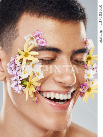 Smile, beauty and a man with flowers on a studio background for creative aesthetic. Happy, plant and a male model with floral art for facial wellness and dermatology isolated on a studio backdrop Smile, beauty and a man with flowers on a studio background for creative aesthetic. Happy, plant and a male model with floral art for facial wellness and dermatology isolated on a studio backdrop 137502610