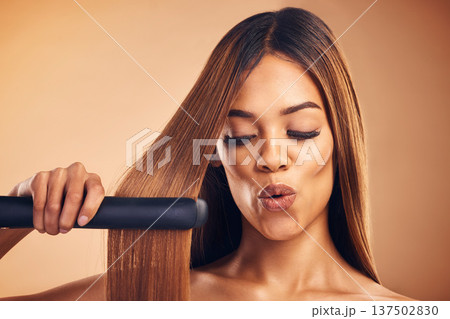 Excited, hair straightener and a woman in studio for beauty, cosmetics or appliance. Aesthetic model on brown background for wow heat treatment, healthy results and hairdresser or salon flat iron 137502830