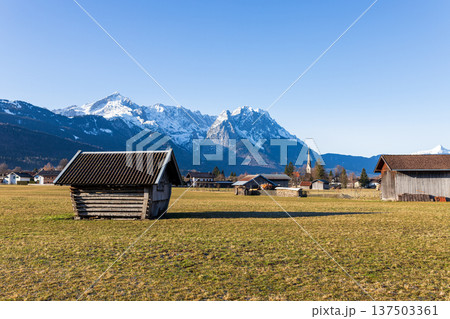 Traditional wooden hut in Bavarian countryside with snow capped Alps mountains and clear blue sky Traditional wooden hut in Bavarian countryside with snow capped Alps mountains and clear blue sky 137503361