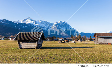Traditional wooden hut in Bavarian countryside with snow capped Alps mountains and clear blue sky Traditional wooden hut in Bavarian countryside with snow capped Alps mountains and clear blue sky 137503366