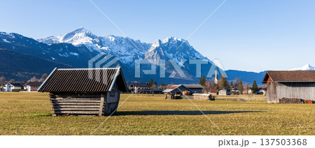 Traditional wooden hut in Bavarian countryside with snow capped Alps mountains and clear blue sky Traditional wooden hut in Bavarian countryside with snow capped Alps mountains and clear blue sky 137503368