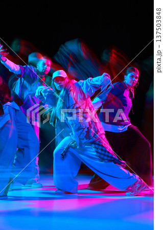 Hip hop dance crew performing dynamic street choreography with neon lighting and motion blur 137503848