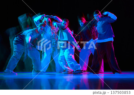 Dance crew performing hip hop choreography with neon lighting and motion blur Dance crew performing hip hop choreography with neon lighting and motion blur 137503853