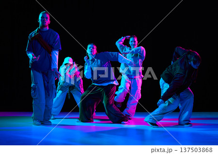 Hip hop dancers performing street dance choreography under neon lighting for music advertising, Hip hop dancers performing street dance choreography under neon lighting for music advertising, 137503868