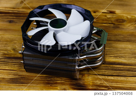 Modern CPU cooler on a wooden desk Modern CPU cooler on a wooden desk 137504008