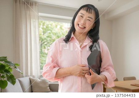 タブレットを持って微笑む女性 137504433