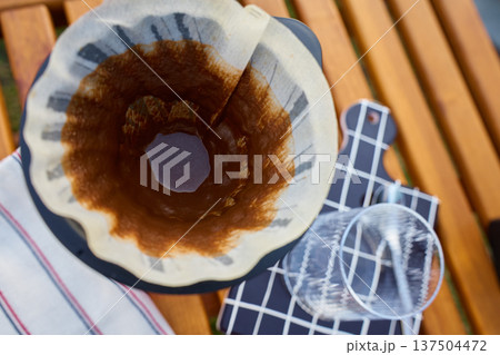 Used coffee filter with grounds residue in dripper on glass carafe Used coffee filter with grounds residue in dripper on glass carafe 137504472