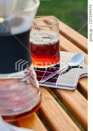 Pour over coffee in ribbed glass on wooden table with carafe Pour over coffee in ribbed glass on wooden table with carafe 137504475