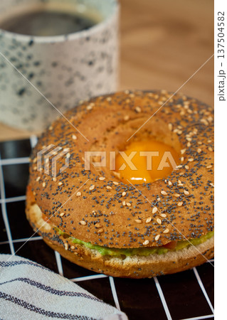 Avocado bagel breakfast sandwich with egg and coffee 137504582