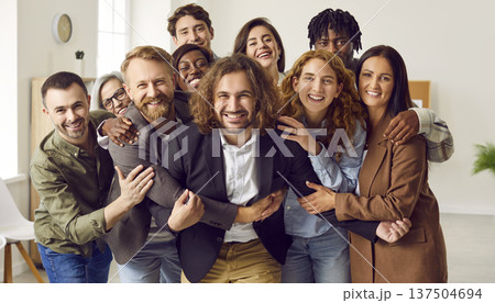 Group of a happy smiling business people looking at camera, having fun and hugging in office. 137504694