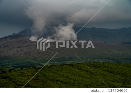 噴煙を上げる阿蘇山の火口 137504695