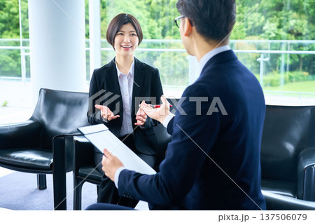 面接で笑顔で話す就職活動中の女性と面接官のビジネスマン 面接で笑顔で話す就職活動中の女性と面接官のビジネスマン 137506079