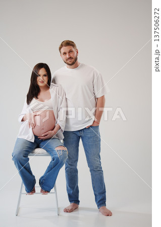 Expecting parents pose together in a cozy studio Expecting parents pose together in a cozy studio 137506272