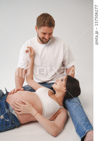 Couple sharing a joyful moment during pregnancy session 137506277