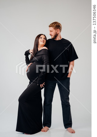 Couple poses for maternity shoot in studio setting Couple poses for maternity shoot in studio setting 137506346