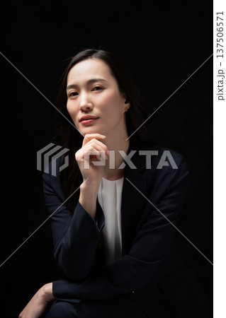スーツを着た30代女性_黒バック スーツを着た30代女性_黒バック 137506571