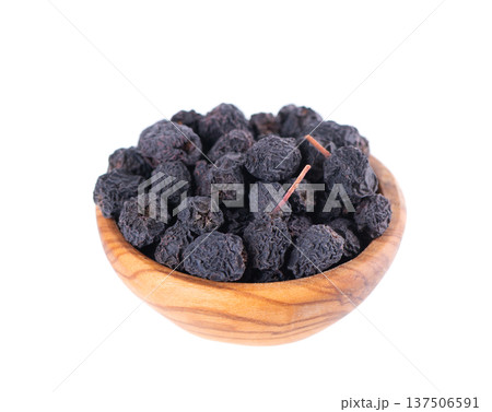 Dried aronia berries isolated on white background. Dry black chokeberry in wooden bowl. Clipping path. 137506591