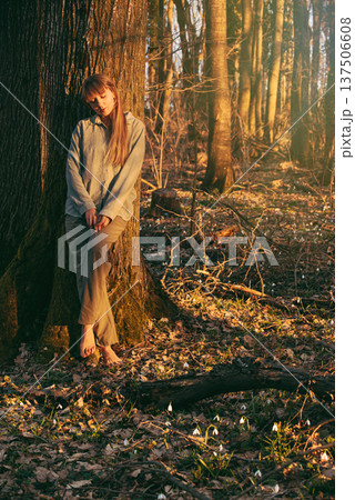Woman Leaning Against Tree in Early Spring Forest Woman Leaning Against Tree in Early Spring Forest 137506608
