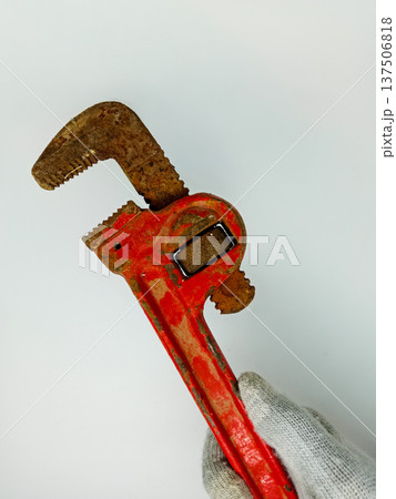 Old rusty pipe wrench in hand on a white background, close-up Old rusty pipe wrench in hand on a white background, close-up 137506818