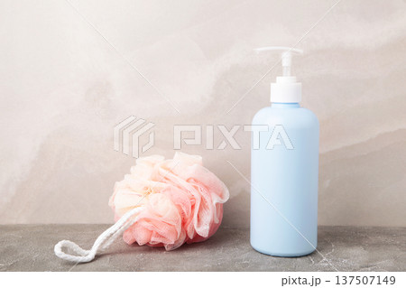 Blue liquid soap dispenser with shower puff on light. Space for text Blue liquid soap dispenser with shower puff on light. Space for text 137507149