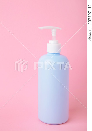 Blue glass liquid soap dispenser on pink background. Vertical photo Blue glass liquid soap dispenser on pink background. Vertical photo 137507150