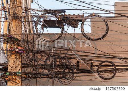 Mess of electrical and internet cables on utility pole in Thailand urban infrastructure Mess of electrical and internet cables on utility pole in Thailand urban infrastructure 137507790