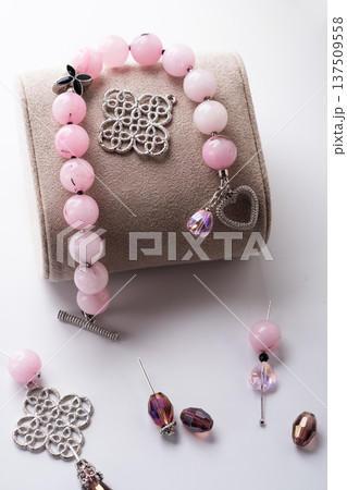 author bracelet with natural cherry jasper and details against white background. fashion and jewelry concept author bracelet with natural cherry jasper and details against white background. fashion and jewelry concept 137509558