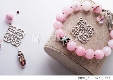 author bracelet with natural cherry jasper and details against white background. fashion and jewelry concept author bracelet with natural cherry jasper and details against white background. fashion and jewelry concept 137509561