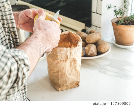 Man's hands peel a potato Man's hands peel a potato 137509806