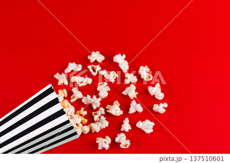 box with popcorn striped in different colors on a red background 137510601