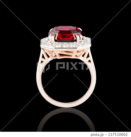 Beautiful red gold ring with diamonds and garnet on a black background 137510602