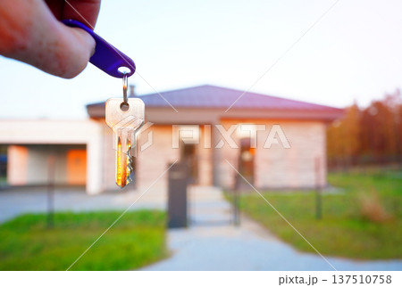 Buying home. Hand holding a bunch of keys at modern private home. Concept of buying real estate 137510758