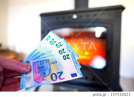 Heating payment. Save money wood stove. Euro money banknotes for payment of heating firewood Heating payment. Save money wood stove. Euro money banknotes for payment of heating firewood 137510821