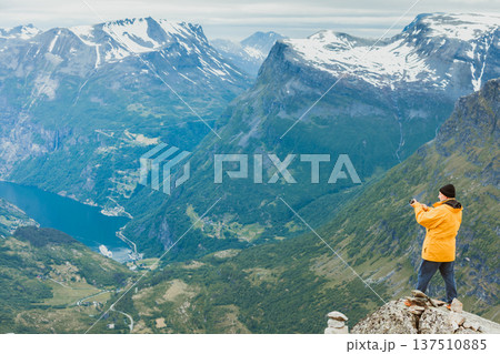 Tourist taking photo from Dalsnibba viewpoint Norway 137510885