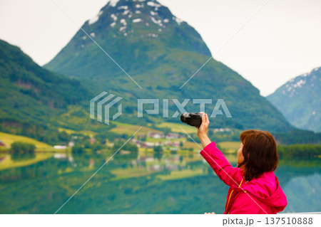 Tourist taking photo at norwegian fjord lake 137510888