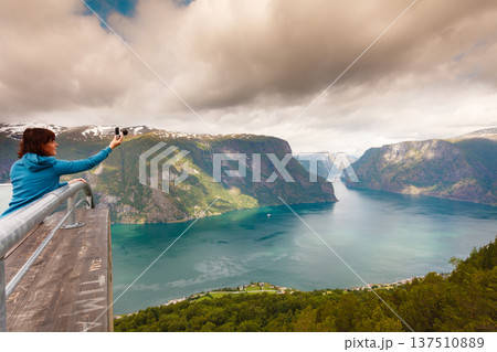 Tourist taking photo from Stegastein viewpoint Norway Tourist taking photo from Stegastein viewpoint Norway 137510889