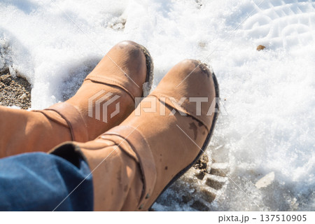 Somebody legs with warm winter shoes on snow Somebody legs with warm winter shoes on snow 137510905