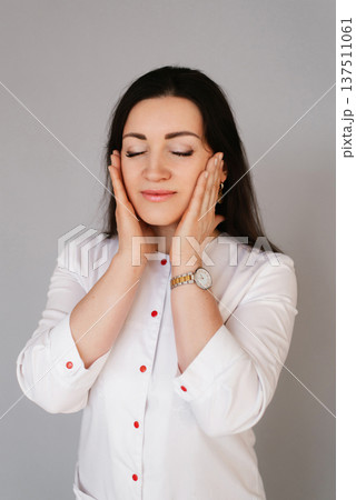 Beautiful Female Doctor with Closed Eyes Touching Face Beautiful Female Doctor with Closed Eyes Touching Face 137511061