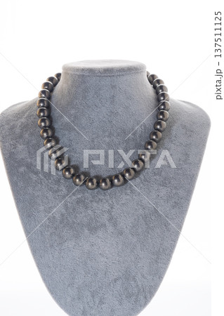 author beautiful  steel color pearls necklaces with heart pendant demonstrated on maneken. fashion and jewelry concept 137511125