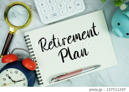 Retirement Plan text written on notepad with piggy bank, calculator, magnifying glass and alarm clock on marble background Retirement Plan text written on notepad with piggy bank, calculator, magnifying glass and alarm clock on marble background 137511297