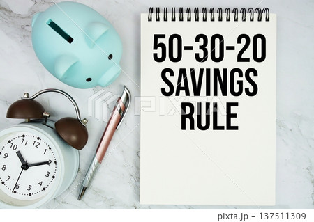 50-30-20 Savings Rule text with piggy bank and alarm clock on marble background 50-30-20 Savings Rule text with piggy bank and alarm clock on marble background 137511309