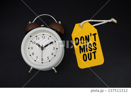 Price tag with message "Do't Miss Out" and alarm clock on black background Price tag with message "Do't Miss Out" and alarm clock on black background 137511312