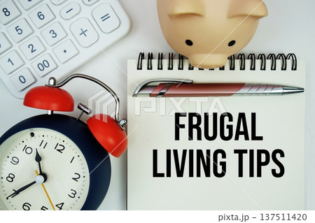 Frugal Living Tips text written notepad with calculator, piggy bank and alarm clock on white background Frugal Living Tips text written notepad with calculator, piggy bank and alarm clock on white background 137511420